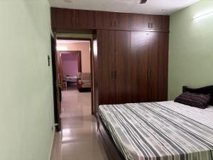 a bedroom with a bed and a wooden cabinet at Satya Residency in Kākināda