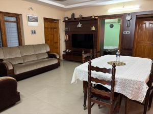 a living room with a table and a couch at Satya Residency in Kākināda