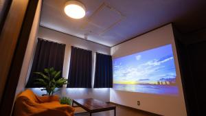 a living room with a large painting on the wall at mintstay kochi in Kochi