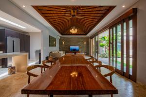 a dining room with a large wooden table and chairs at Kejora Beachfront Villas in Sanur