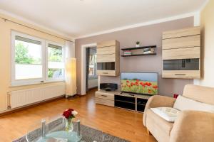 a living room with a couch and a tv at Bungalow Becker "Am Feldrand" in Jennewitz