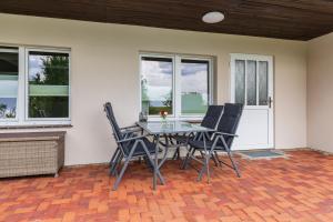 a dining room table and chairs on a patio at Bungalow Becker "Am Feldrand" in Jennewitz