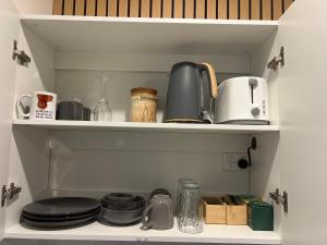 a cupboard filled with lots of kitchen items at Lakeside Riverfront Yamba 1-2 Small Pet Friendly in Yamba +22 photos