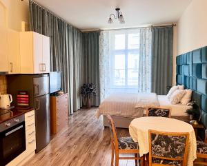 a hotel room with a bed and a table and chairs at Apartamenty i Studia HERBARIUM in Krakow