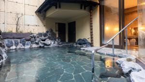 ein Wasserbecken mit Steinen in einem Haus in der Unterkunft HOTEL nehako in Hakone