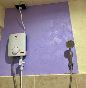 a purple wall with an electrical outlet and a plug at MIKI's Guest House in Siquijor