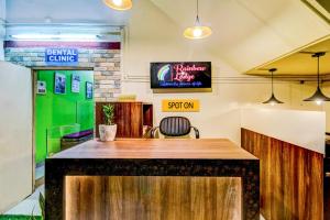 a bar in a restaurant with a tv on the wall at SPOT ON Rainbow Lodge in Guwahati +24 photos