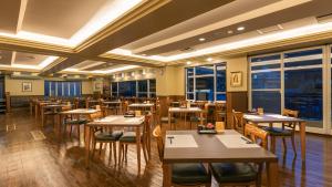 ein Restaurant mit Holztischen und -stühlen und Fenstern in der Unterkunft HOTEL nehako in Hakone