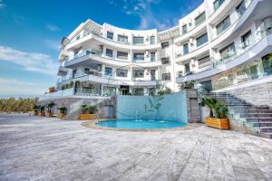 an apartment building with a swimming pool in front of it at OXANA By Atlasia in Agadir