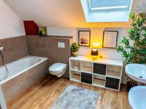 a bathroom with a tub and a toilet and a sink at Privates Team-Haus nahe VW Wolfsburg I 4-5 Schlafzimmer, Einzelbetten, perfekt für Monteure, Teams und Reisegruppen I Parkplatz I Rechnung mit MwSt in Calberlah