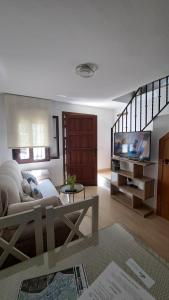 a living room with a couch and a tv at Vivienda Rural Sentirte La Casita in Aracena +15 photos