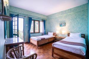 a bedroom with two beds in a room with blue walls at Bamboo Retreat Hotel in Gangtok +189 photos