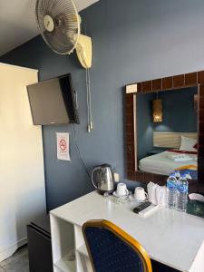 a room with a desk with a fan and a bed at Istanbul Boutique Hotel in Patong Beach