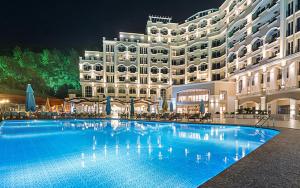 a large building with a large swimming pool at night at Angel's Marmaris Hotel in Turgut