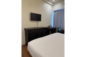 a bedroom with a bed and a flat screen tv at The Shivanta Inn in Ābu Road