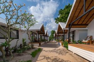 a walkway between two houses with trees at The Cosy Sunset Beach Resort in Thong Sala