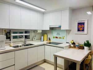 a kitchen with white cabinets and a table at 후암가옥 in Seoul