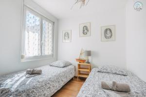 a bedroom with two beds and a window at 11- Clapotis de l'Ô - Balcon sur la Mer - Parking Privé in Ault