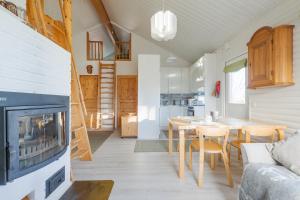 a living room with a fireplace and a table and chairs at Järven Helmi in Äkäslompolo