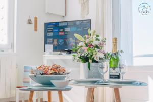 a table with a bowl of food and a vase of flowers at 11- Clapotis de l'Ô - Balcon sur la Mer - Parking Privé in Ault