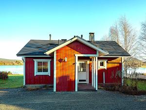 a small red house with a white door at Järven Helmi in Äkäslompolo