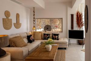 a living room with a couch and a tv at Soborgo Exquisite Villas in Tinos