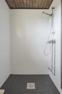 a shower in a bathroom with white walls at Järven Helmi in Äkäslompolo +11 photos