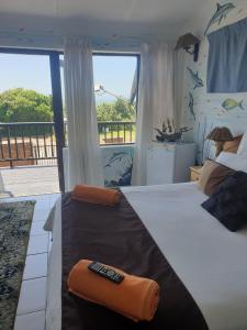 a bedroom with a bed with a remote control on it at Deep Blue Guest House in Amanzimtoti