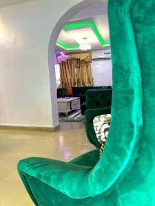 a room with a green chair in a room at The John Apartment in Murtala Muhammed International Airport +5 photos