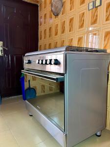 a stainless steel oven in a kitchen with wooden cabinets at The John Apartment in Murtala Muhammed International Airport