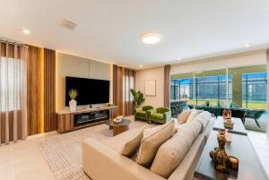 a living room with a couch and a television at Spacious 9BR Home w Private PoolGame Room in Davenport