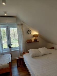 a bedroom with a bed and a clock on the wall at Domek Kaprys Piatkowa in Piątkowa