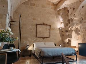 a bedroom with a bed in a stone wall at Dimore dei Mercanti in Matera +87 photos