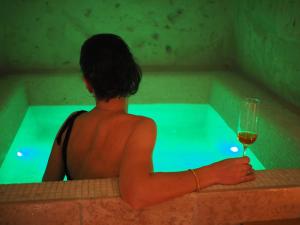 a man sitting in a tub with a glass of wine at Dimore dei Mercanti in Matera