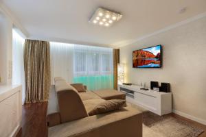 ein Schlafzimmer mit einem Bett und einem Fernseher an der Wand in der Unterkunft The Queen Luxury Apartments - Villa Vinicia in Luxemburg (Stadt)