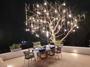a table and chairs under a tree with lights at La Fenice Resort Madh Island in Mumbai