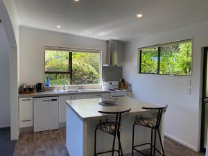 a kitchen with a counter and two bar stools at Harbour View on Buller in Picton