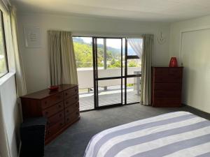 a bedroom with a bed and a dresser and a window at Harbour View on Buller in Picton
