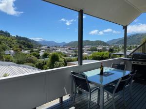 a table and chairs on a balcony with a view at Harbour View on Buller in Picton