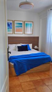 a bedroom with a large bed with a blue blanket at Apartamento Chay in Málaga +62 photos