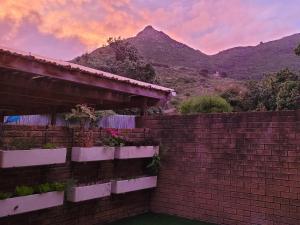 a brick wall with a mountain in the background at Leehaven in Hout Bay