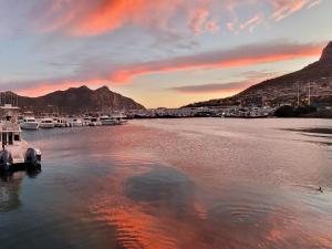 a marina with boats in the water at sunset at Leehaven in Hout Bay