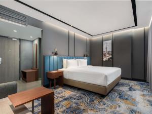 a hotel room with a bed and a table and a couch at Mercure Jakarta Grogol in Jakarta +24 photos