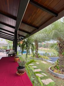 a red table with potted plants on a patio at Namkhan Rivora Resort in Luang Prabang