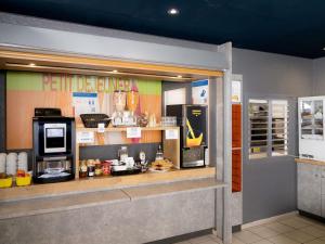 a store front with a counter with a microwave at Ibis budget Périgueux in Périgueux +14 photos