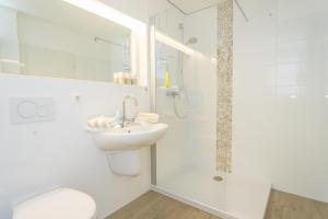 a white bathroom with a toilet and a sink at Weststrand, App 11 "Seewind" in Westerland