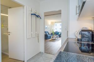a kitchen with a glass door leading into a living room at Weststrand, App 11 "Seewind" in Westerland +20 photos