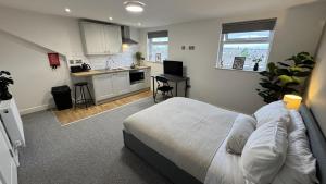 a bedroom with a large bed and a kitchen at Camden St Accommodation in Derby