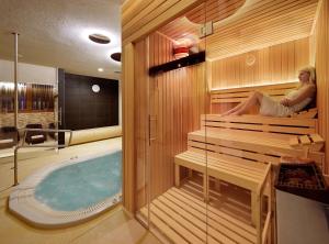 a woman sitting in a sauna with a hot tub at Villa Gardenia in Donovaly
