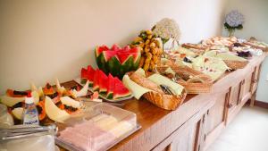 a buffet of food on a wooden table at Pousada Monjolos de Minas a 9 km de Gonçalves in Gonçalves